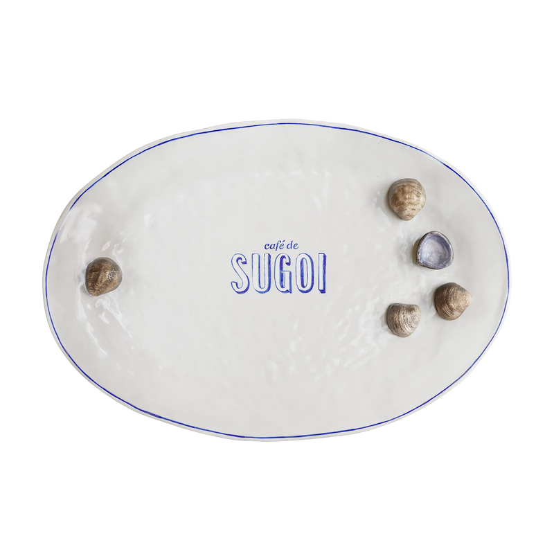 Håndlavet hvid tallerken fra Sugoi Studio med blå Café de Sugoi-logo og muslingedetaljer – legesyg og unik til moderne borddækning.